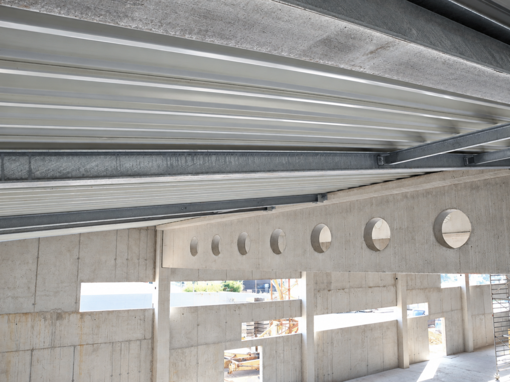 Rohbau der Eventhalle in Kelkheim mit Sichtbeton, kreisförmigen Öffnungen und Stahltragwerk